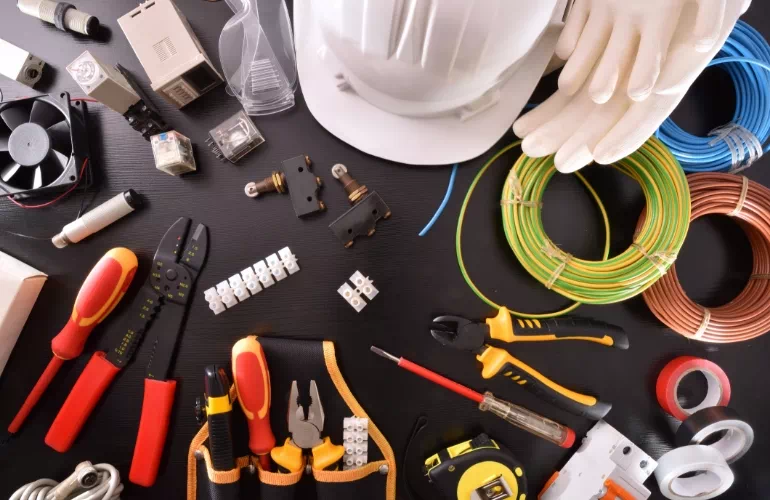 kompozycja płąska przzedstawiająca kable, kask i inne artykuły elektryczne